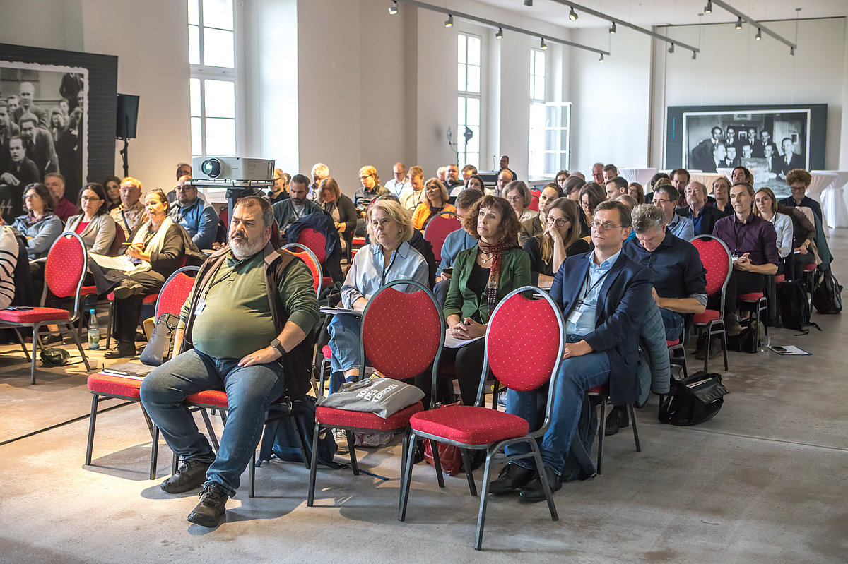 Foto der Konferenz: Teilnehmende sitzen im Publikum