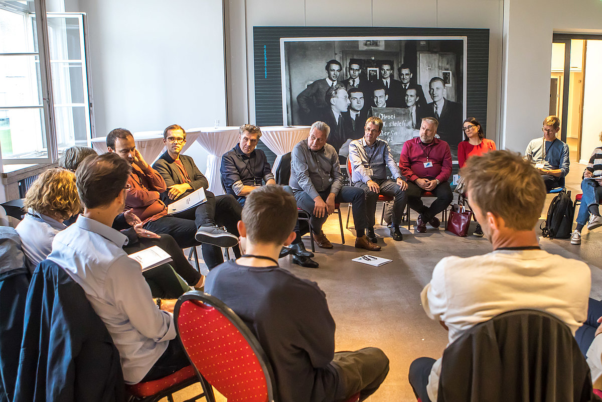Foto der Konferenz: Teilnehmende diskutieren im Stuhlkreis